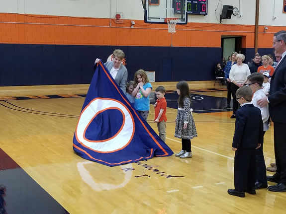 Paul Rickard's wife Maureen unveiling a logo on the floor that read “Paul Rickard Court” during halftime of Orange’s game against Kingsborough Community College.