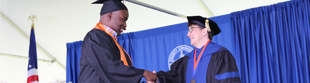 Student shaking hands with president Dr. Young at commencement