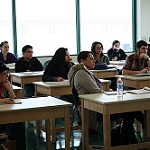 Photo: Female and Male Students Sitting at Desks in Classroom