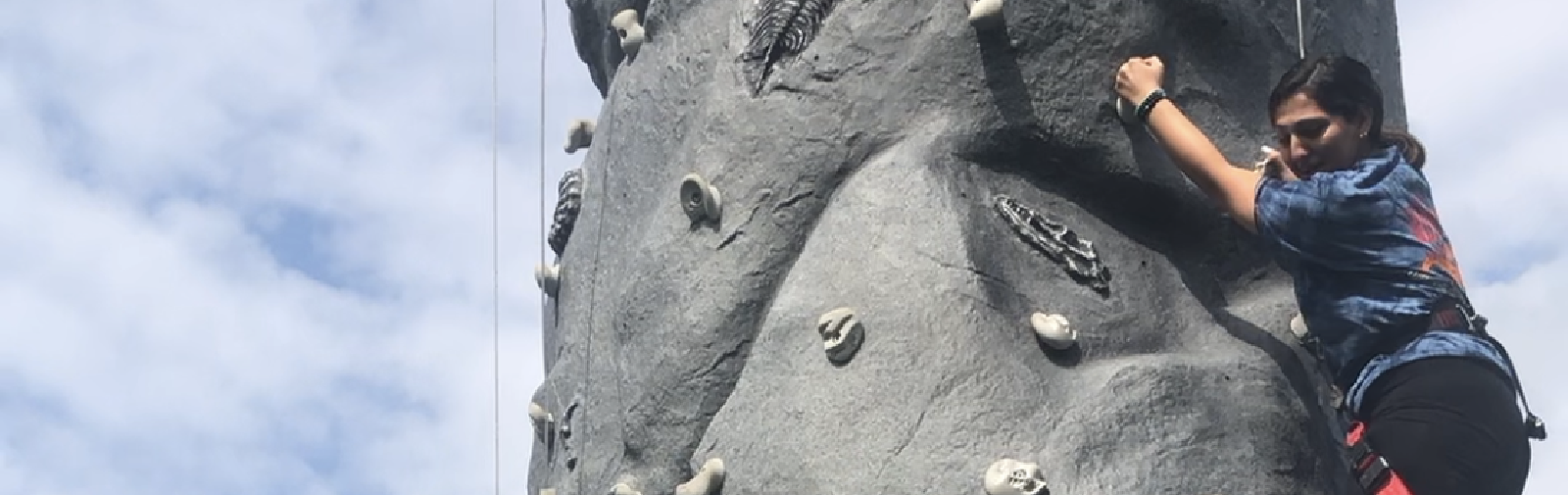 student climbing rock wall