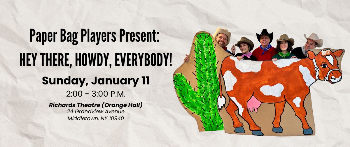 cast of the paper bag players smiling into camera dresses as cowboys behind a paper cow