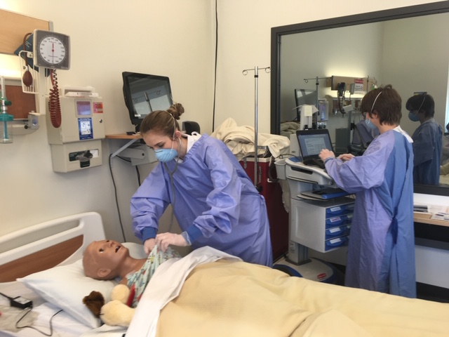 Nursing students working in a simulated hospital room