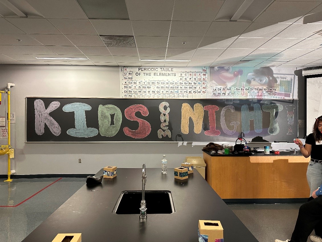 Chalkboard with Kids Chem Night written in colorful chalk